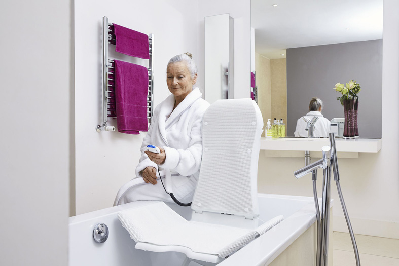 Badewannenlifter bei Reha-Technik direkt Frau imm Badezimmer die einen Badewannenlifter bedient